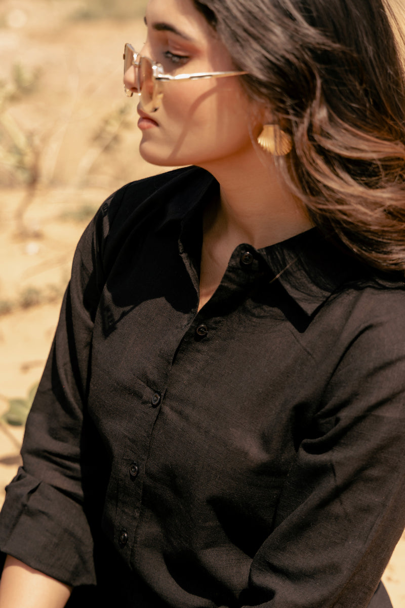 Woman wearing a black shirt with a blurred natural background