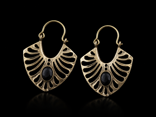 Pair of gold earrings with black stones on a black background