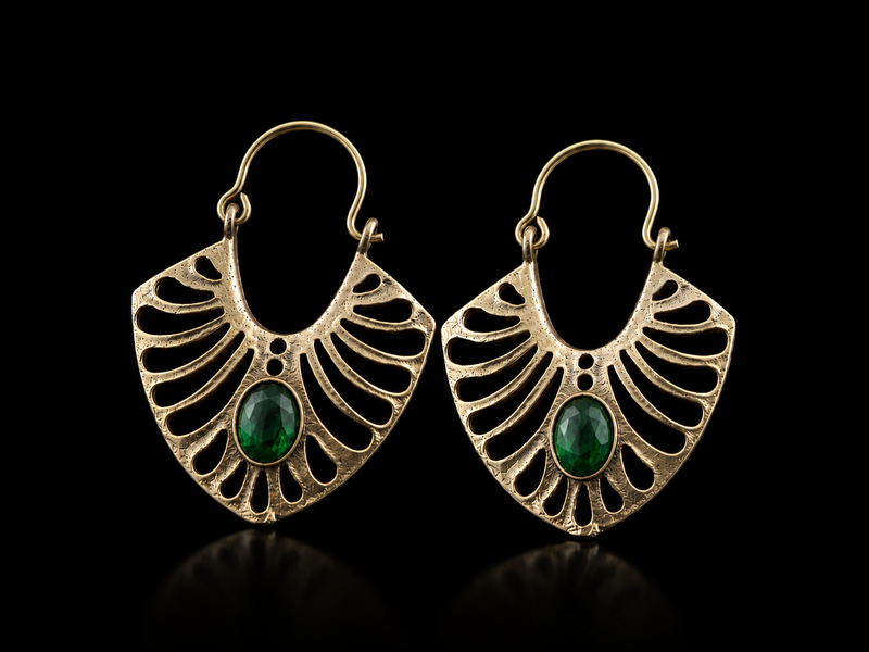 Pair of gold earrings with green gemstones on a black background