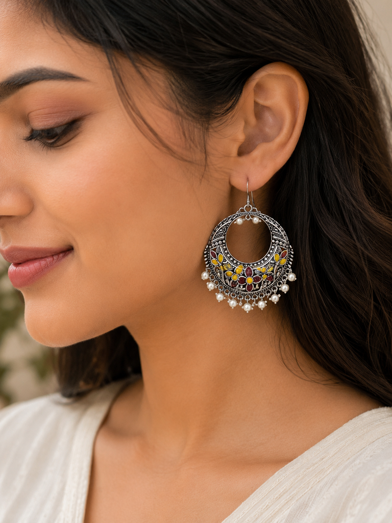 Close-up of a woman wearing intricate earrings with a blurred background