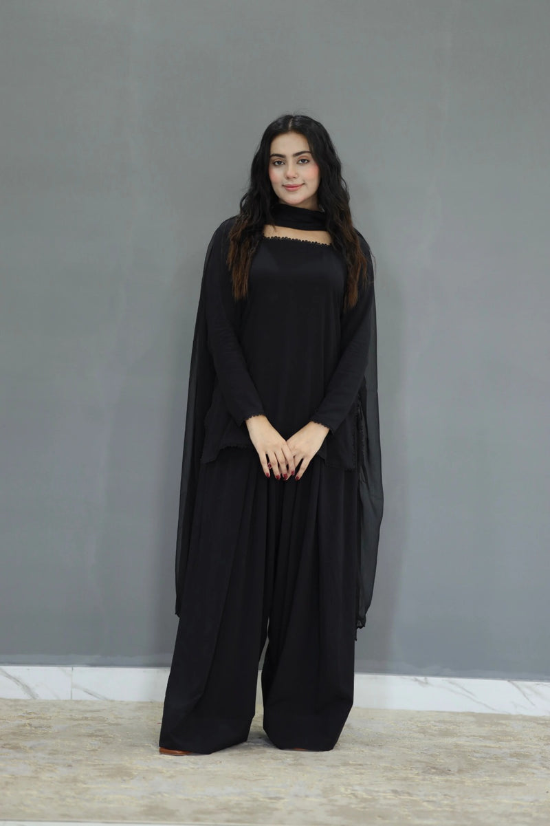 Woman wearing a black outfit against a gray background