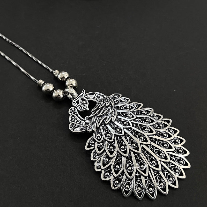 Silver peacock feather pendant necklace on a black background