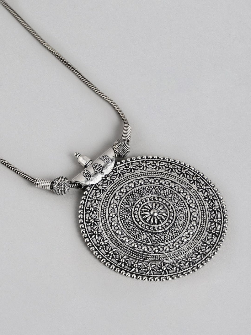 Silver necklace with a detailed circular pendant on a light gray background