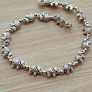 Silver elephant bracelet on a wooden surface