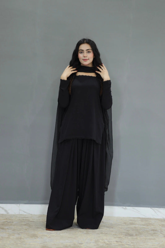 Woman wearing a black outfit against a gray background