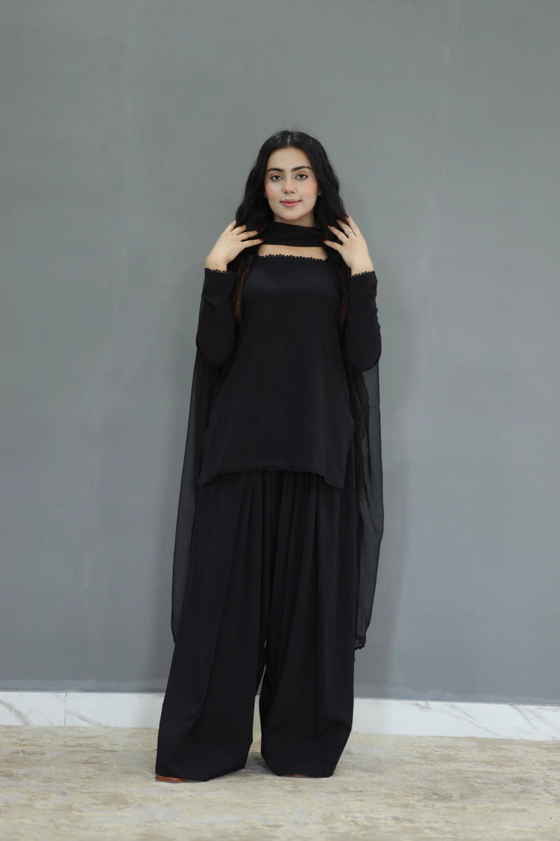 Woman wearing a black outfit against a gray background