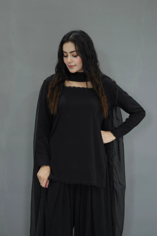 Woman wearing a black outfit against a gray background