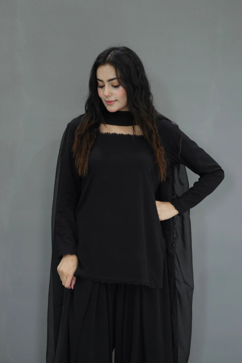 Woman wearing a black outfit against a gray background